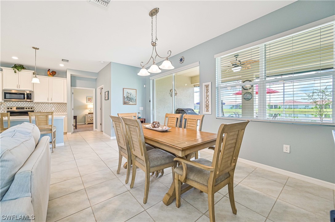 3435 Gold Flower Street Fort Myers, FL 33905 - Photo 18 of 39 a view of a dining room and livingroom with furniture wooden floor a chandelier