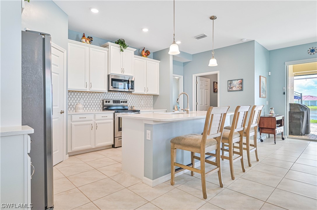 3435 Gold Flower Street Fort Myers, FL 33905 - Photo 21 of 39 a kitchen with cabinets and chairs