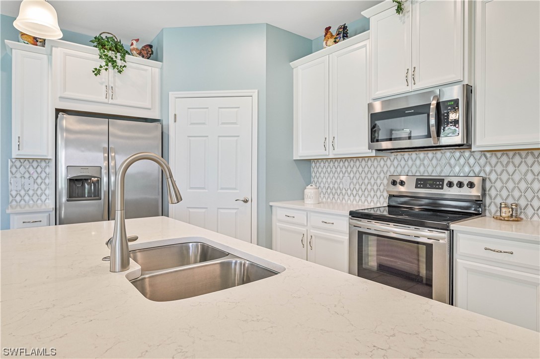 3435 Gold Flower Street Fort Myers, FL 33905 - Photo 22 of 39 a kitchen with granite countertop a stove a sink and a microwave