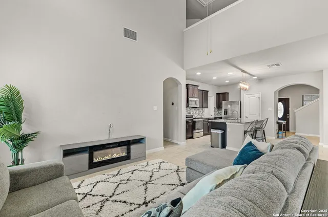 a living room with furniture and a dining area with kitchen view