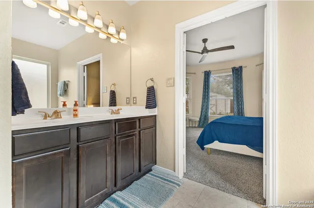 a en suite bathroom with a double vanity sink a mirror and a bathtub