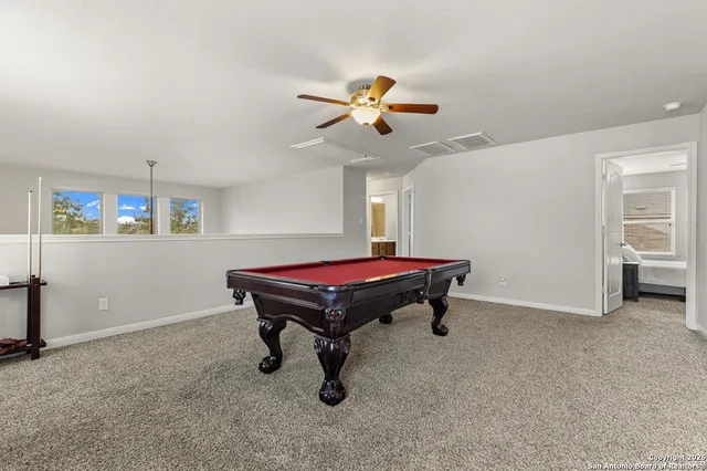 a room with pool table and windows