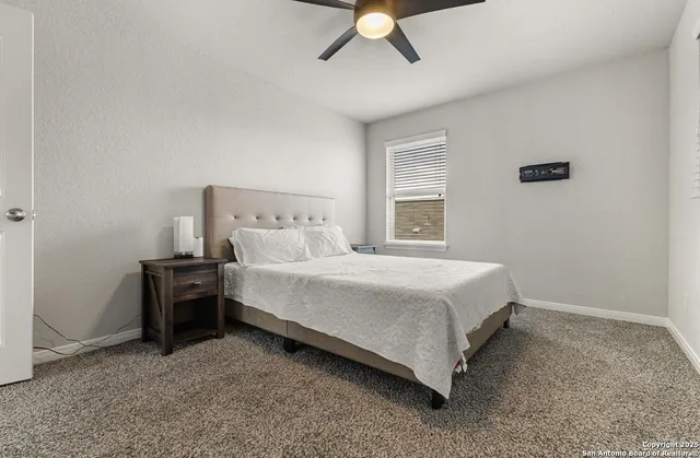 a bed sitting in a spacious bedroom next to a window