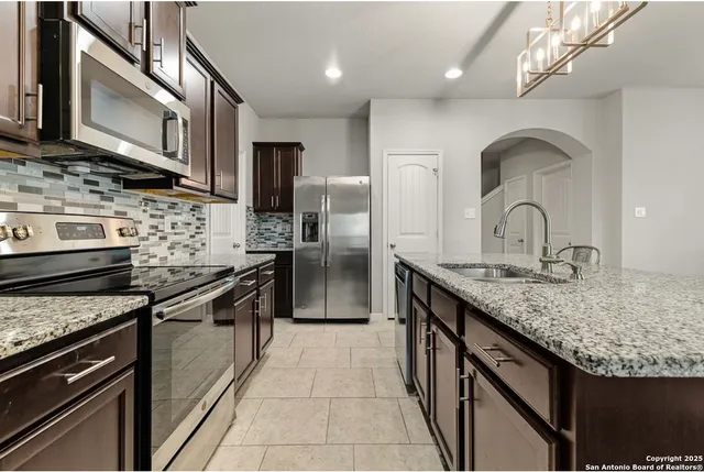 a kitchen with stainless steel appliances granite countertop a stove top oven a sink and dishwasher