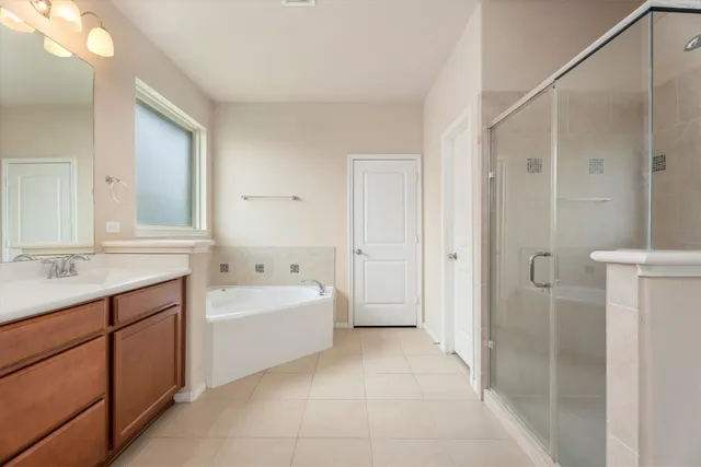a spacious bathroom with a bathtub shower and a sink
