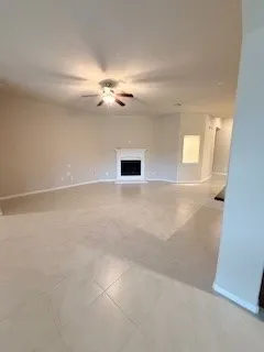 an empty room with windows and fan