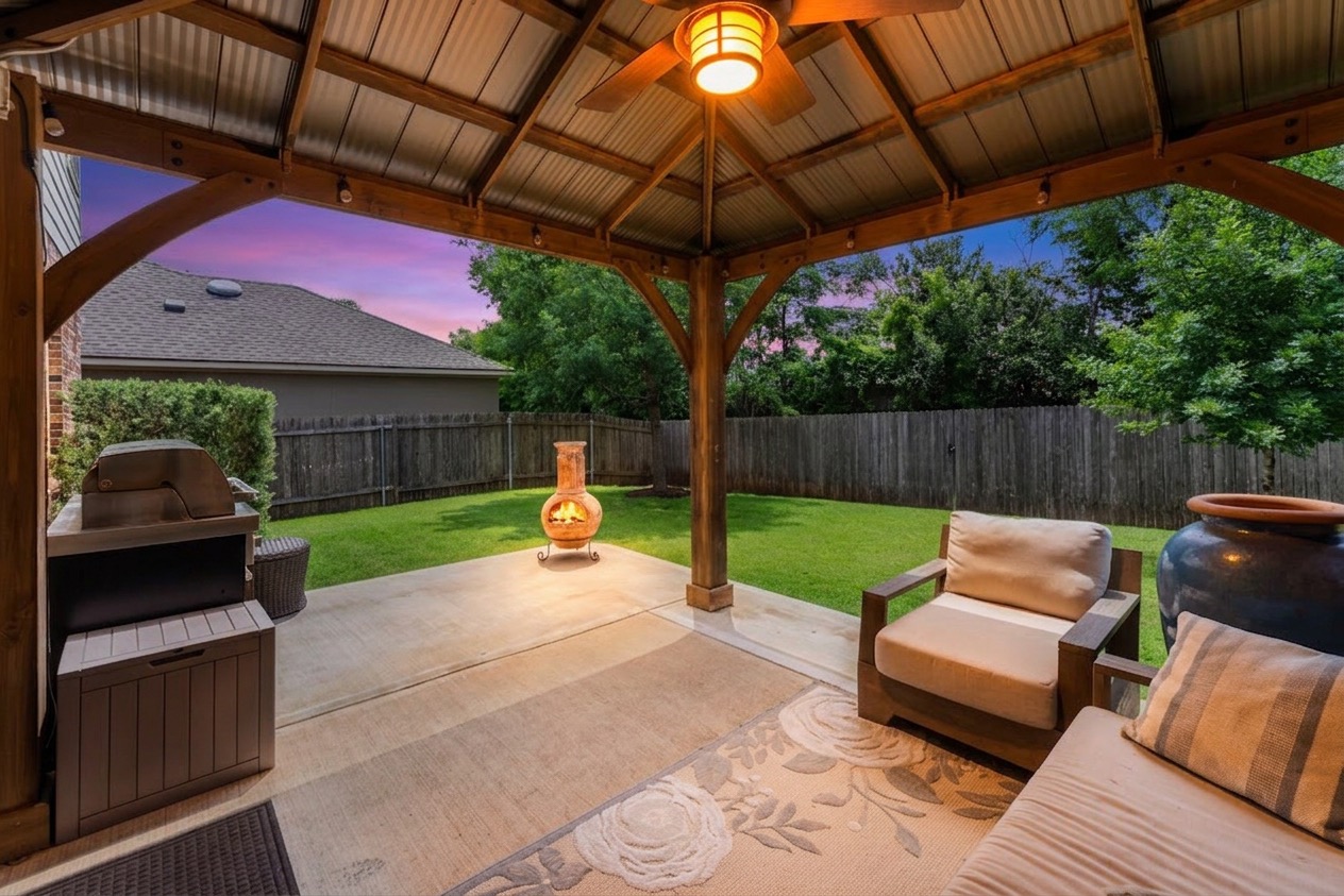 1133 Yellow Iris Road Leander, TX 78641 - Photo 33 of 37 Covered patio featuring a corrugated metal roof with exposed wood beams, a ceiling fan with integrated lighting, and string lights