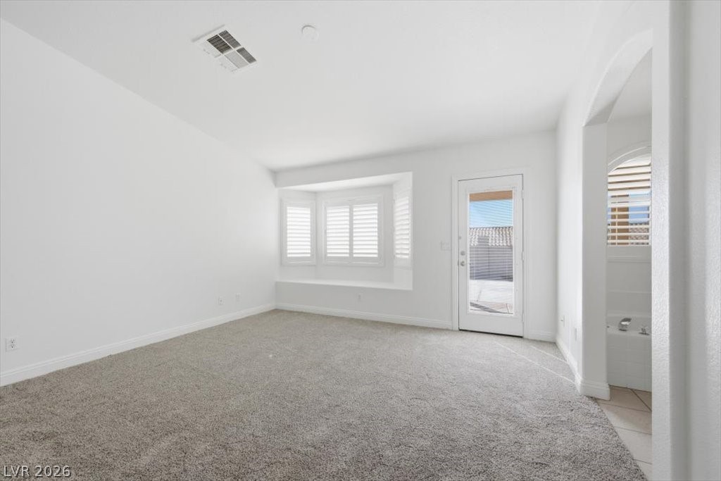 573 Beryl Court Henderson, NV 89015 - Photo 29 of 52 Deluxe primary bedroom with vaulted ceilings, a cozy window seat, a French door to the backyard and brand new carpet.