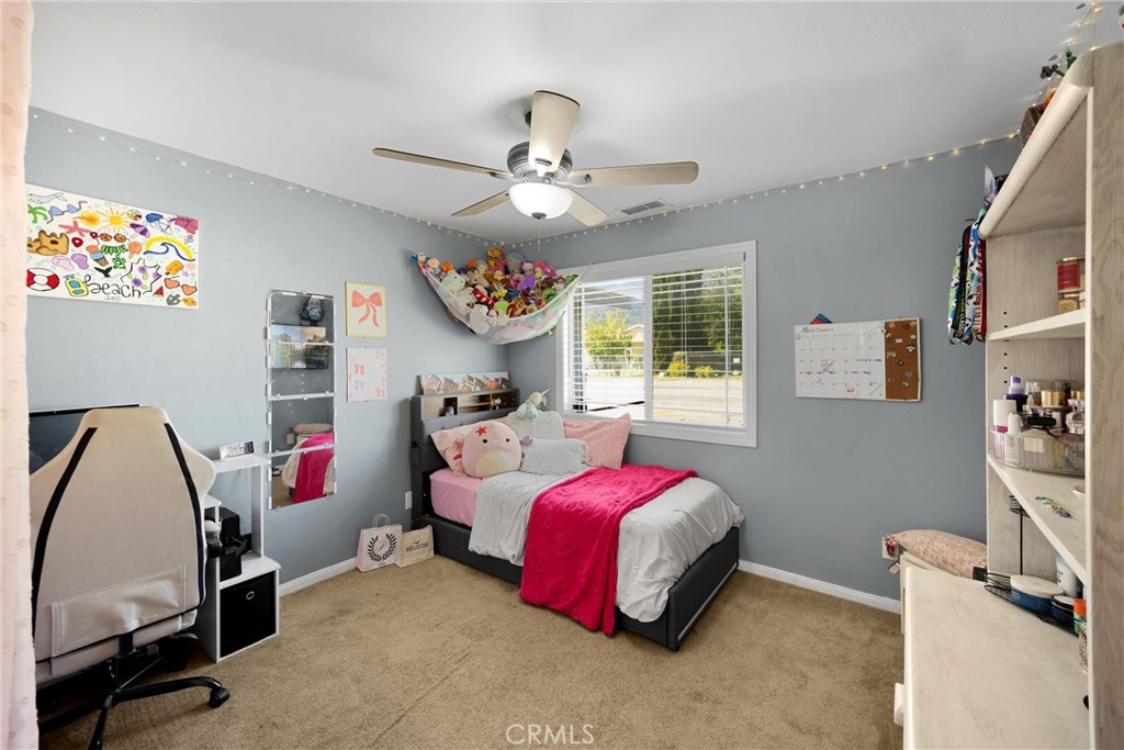 14508 Cabazon Street Cabazon, CA 92230 - Photo 13 of 22 a bedroom with a bed and a chandelier