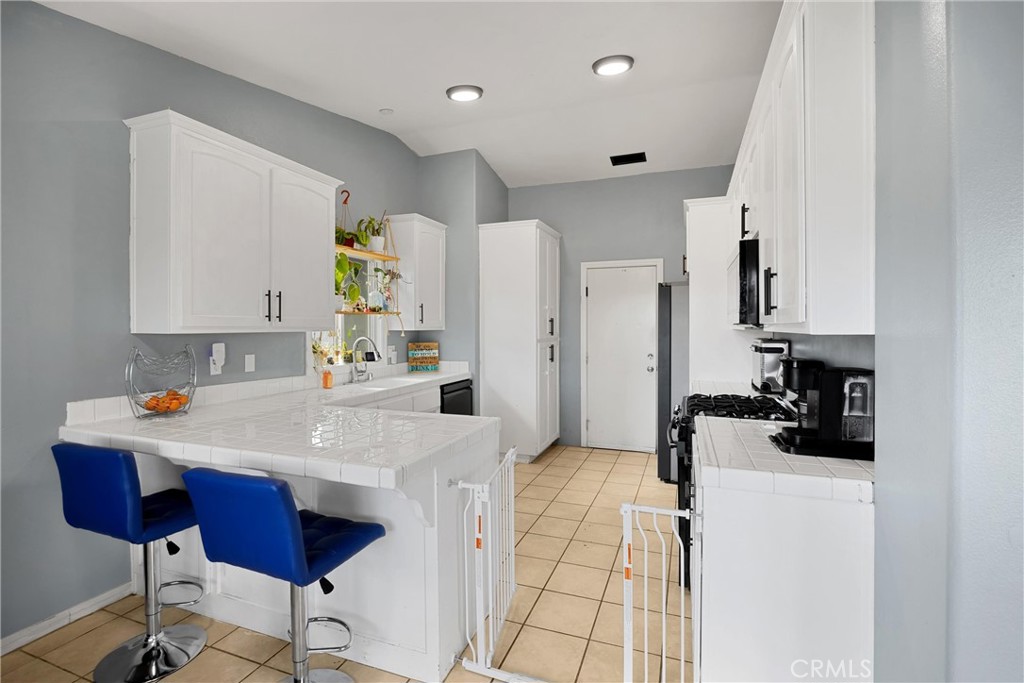 14508 Cabazon Street Cabazon, CA 92230 - Photo 8 of 22 a kitchen with stainless steel appliances a sink a stove a refrigerator cabinets and a dining table