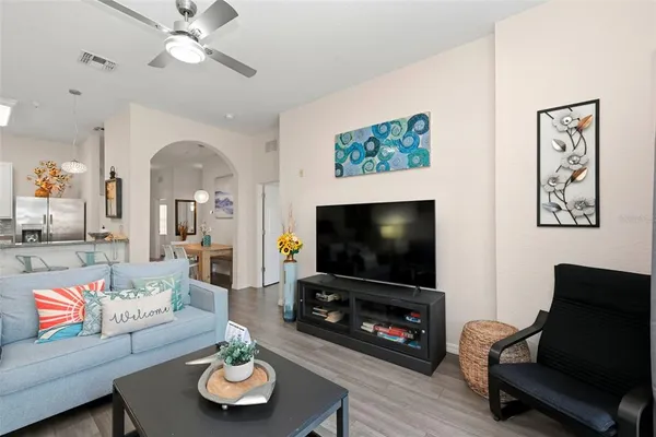 a living room with furniture and a flat screen tv with wooden floor