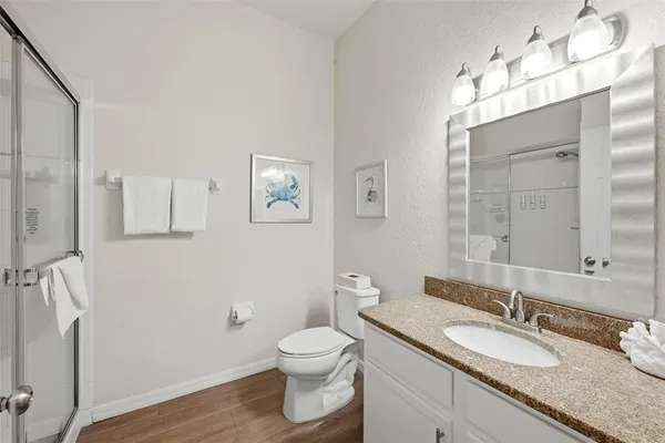a bathroom with a granite countertop sink mirror vanity and toilet