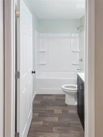 a view of an empty room with a chandelier fan