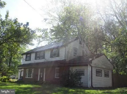 a view of a yard in front of a brick house with large windows