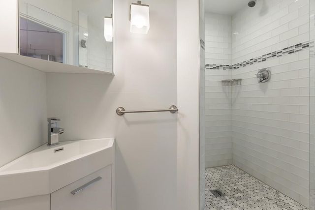 a bathroom with a sink a shower and a mirror