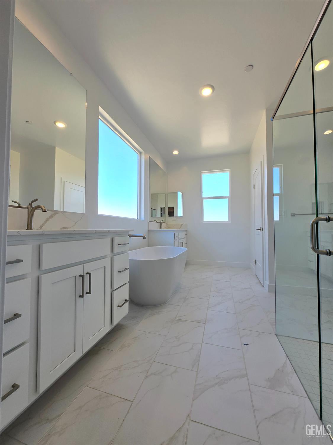 Undisclosed Address Bakersfield, CA 93306 - Photo 14 of 21 a large bathroom with a large mirror vanity and a shower