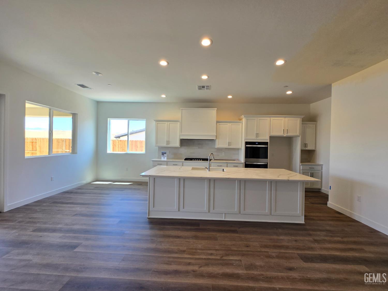 Undisclosed Address Bakersfield, CA 93306 - Photo 8 of 21 a view of kitchen with kitchen island a sink wooden floor and a living room view