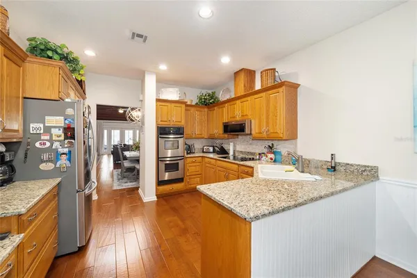a kitchen with stainless steel appliances granite countertop a sink refrigerator and cabinets