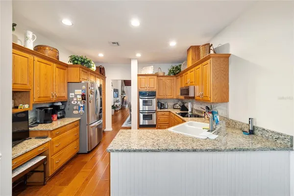 a kitchen with stainless steel appliances kitchen island granite countertop a sink and cabinets