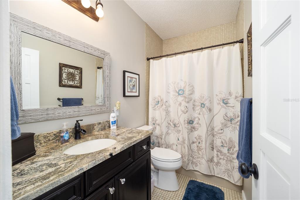 1731 Southeast Clatter Bridge Road Ocala, FL 34471 - Photo 29 of 52 a bathroom with a granite countertop sink toilet and shower