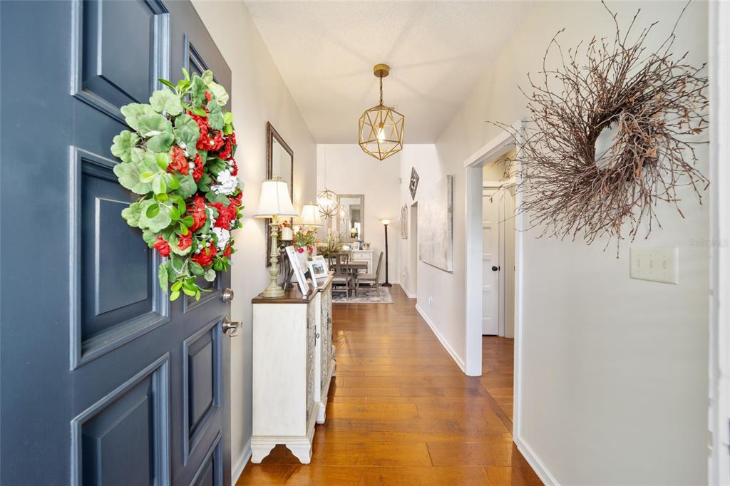 1731 Southeast Clatter Bridge Road Ocala, FL 34471 - Photo 4 of 52 a hallway with beautiful flowers and wooden floor