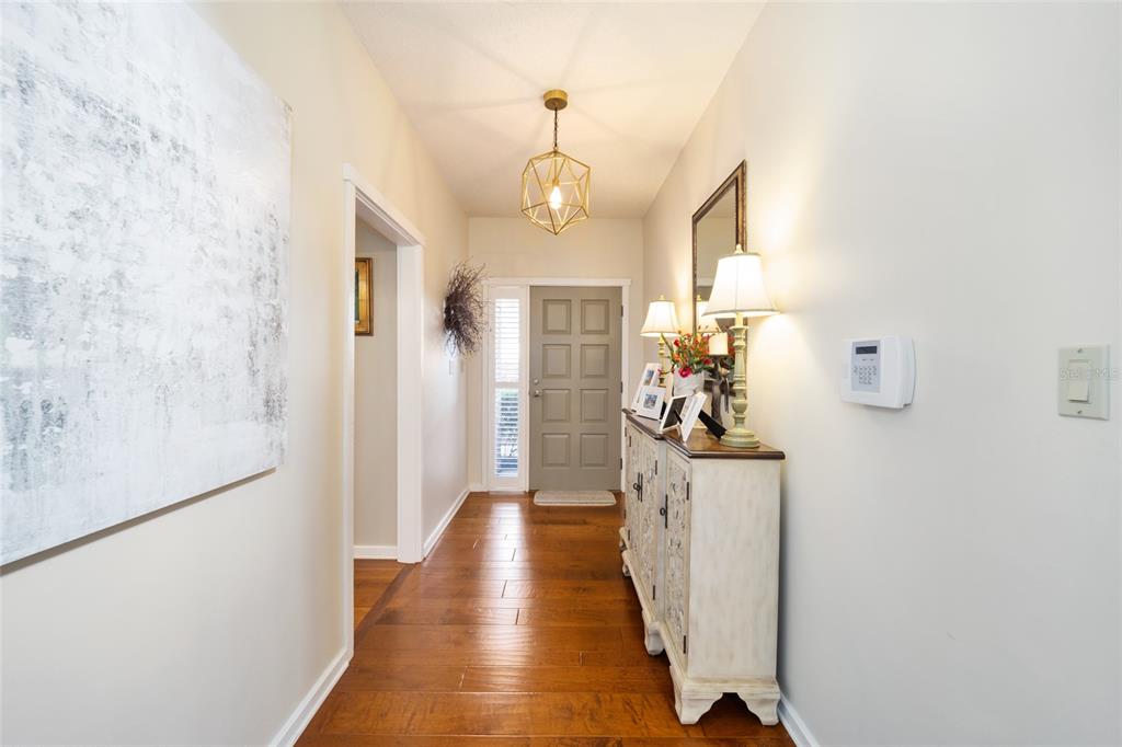 1731 Southeast Clatter Bridge Road Ocala, FL 34471 - Photo 5 of 52 a view of a hallway with wooden floor windows and a chandelier