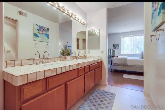 a spacious bathroom with a tub sink and mirror