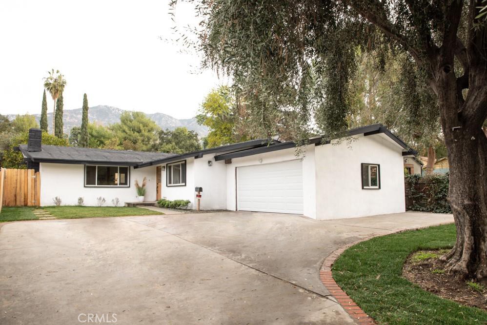 front view of house with a yard and trees around