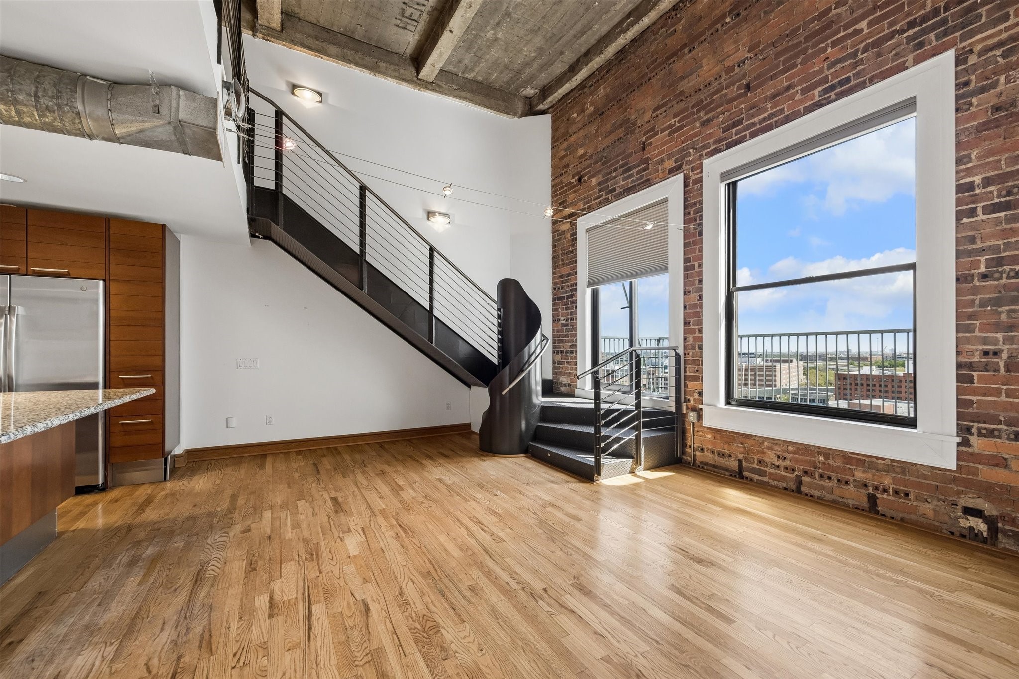 915 Franklin Street, Unit 9L Houston, TX 77002 - Photo 7 of 50 Bright dining area with an exposed brick wall, large window, and abundant natural light.