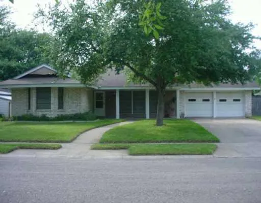 a front view of a house with a garden and trees