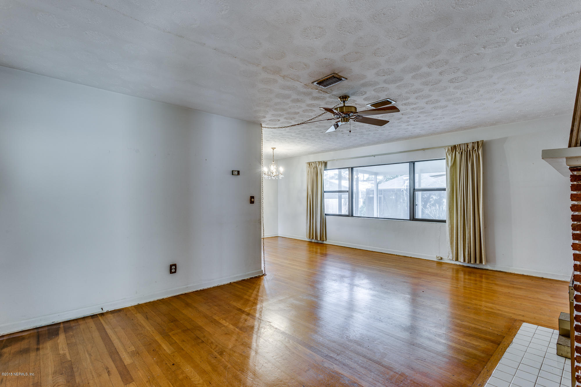 6335 Temple Road Jacksonville, FL 32217 - Photo 8 of 46 a view of an empty room with a window and wooden floor
