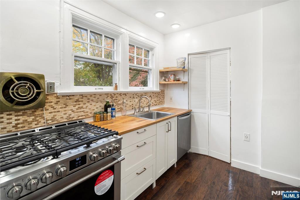 401 Conrad Road Englewood, NJ 07631 - Photo 16 of 42 a kitchen with stainless steel appliances granite countertop a stove and a sink