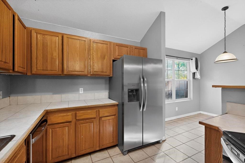 109 Pleasant Run Azle, TX 76020 - Photo 15 of 40 a kitchen with stainless steel appliances granite countertop a refrigerator a sink and dishwasher with wooden cabinets