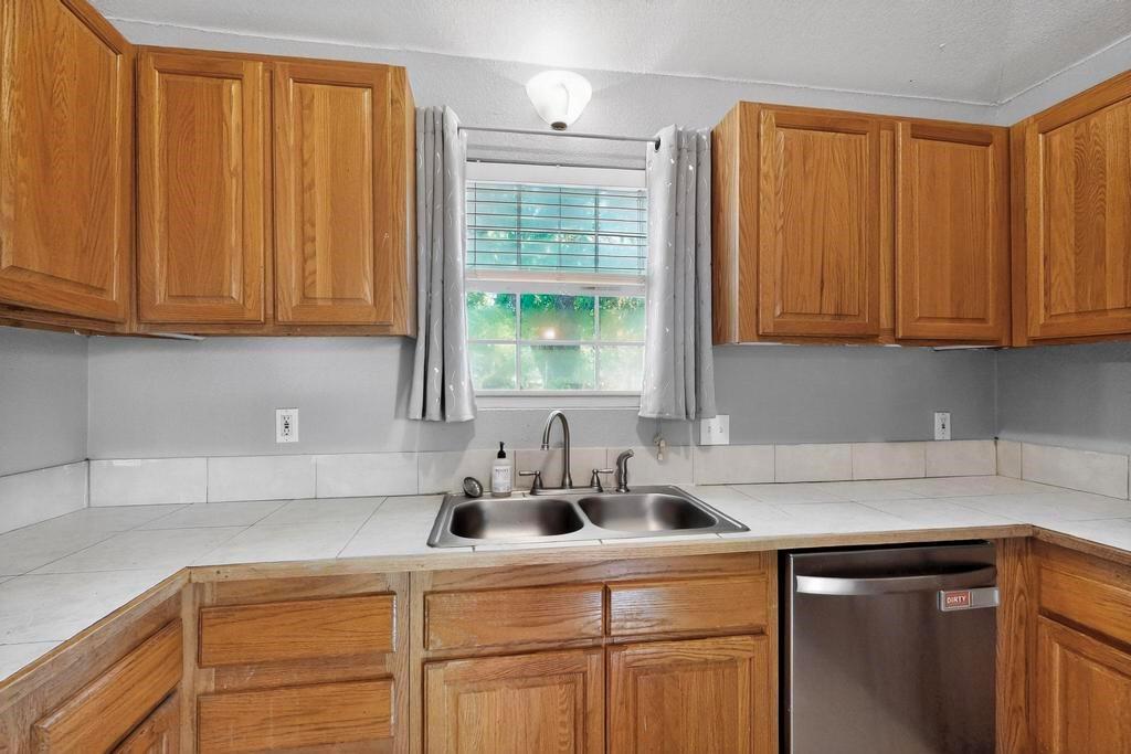 109 Pleasant Run Azle, TX 76020 - Photo 18 of 40 a kitchen with stainless steel appliances granite countertop a sink cabinets and a window