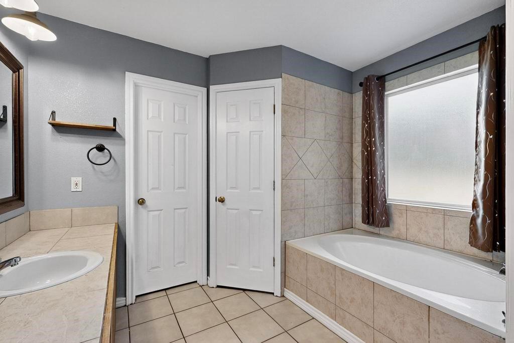 109 Pleasant Run Azle, TX 76020 - Photo 23 of 40 a bathroom with a bathtub and a sink