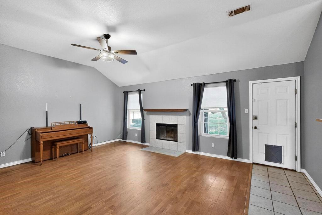 109 Pleasant Run Azle, TX 76020 - Photo 10 of 40 a view of a livingroom with a fireplace a ceiling fan and windows