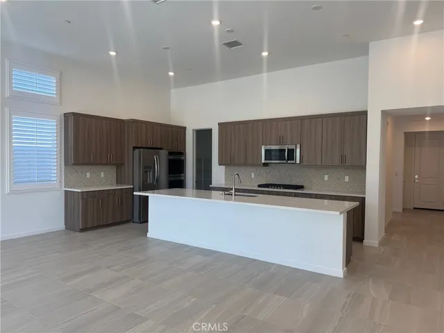 a kitchen with a sink a counter top space and stainless steel appliances