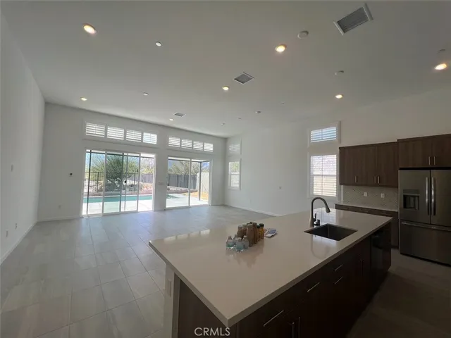 a large kitchen with stainless steel appliances granite countertop a sink a stove and a refrigerator