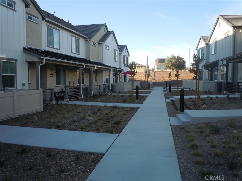 32402 Brunello Way Temecula, CA 92591 - Photo 2 of 22 a view of a white house with large windows next to a yard