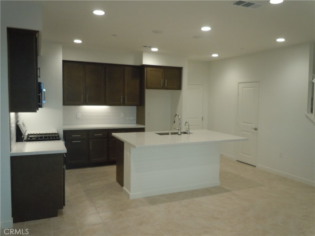 32402 Brunello Way Temecula, CA 92591 - Photo 9 of 22 a kitchen with kitchen island a sink stainless steel appliances and cabinets