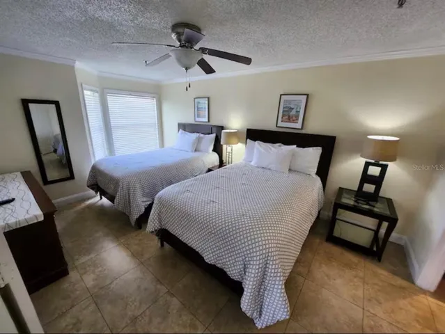 a bedroom with two beds and a ceiling fan