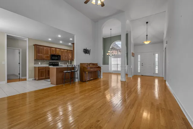 a view of a kitchen with kitchen island a sink wooden floor and a large window