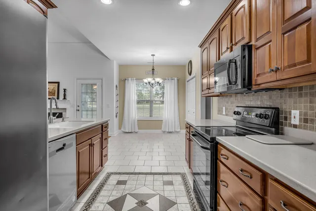 a kitchen with stainless steel appliances granite countertop a stove a sink dishwasher and a refrigerator