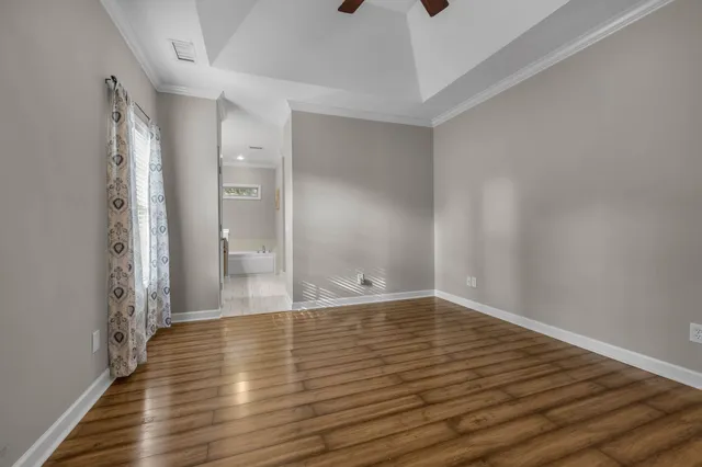 a view of an empty room with wooden floor