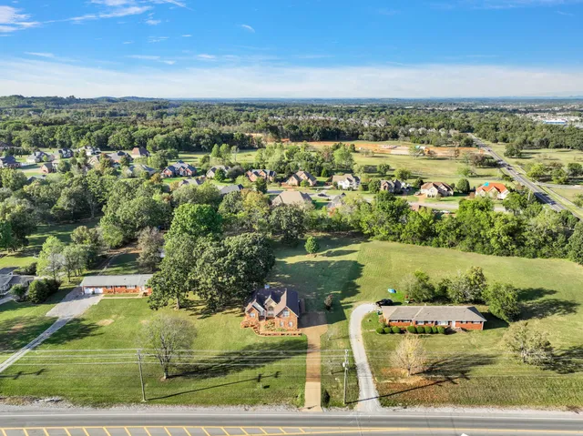 an aerial view of a residential houses with outdoor space and swimming pool