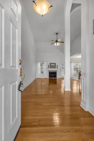 a view of empty room with kitchen view and wooden floor
