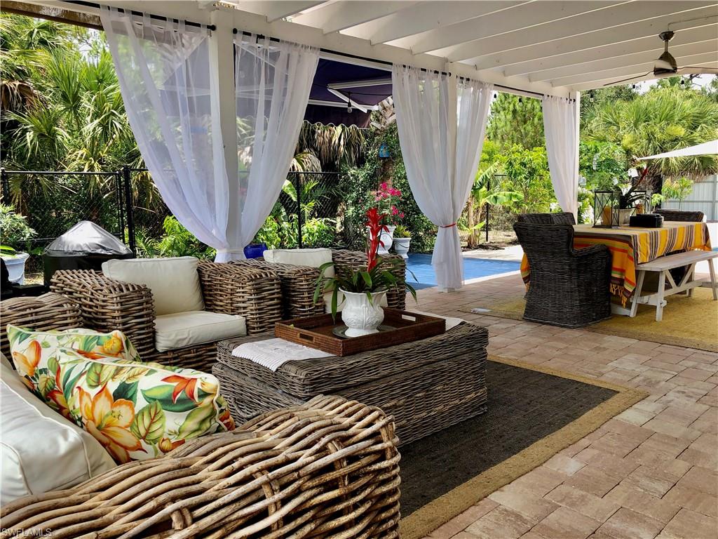 283 Cypress Way West Naples, FL 34110 - Photo 4 of 18 Kitchen with appliances with stainless steel finishes, white cabinets, a kitchen bar, tasteful backsplash, and light tile patterned floors