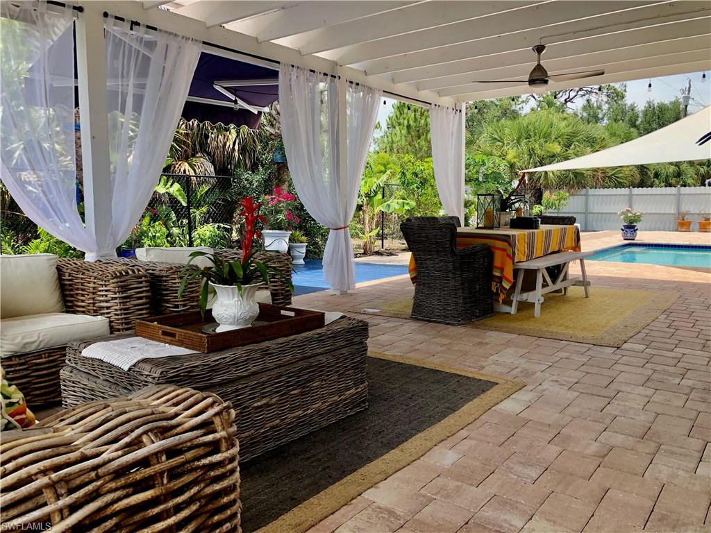 283 Cypress Way West Naples, FL 34110 - Photo 5 of 18 Kitchen featuring stainless steel refrigerator with ice dispenser, a kitchen breakfast bar, dark countertops, white cabinets, and light tile patterned floors