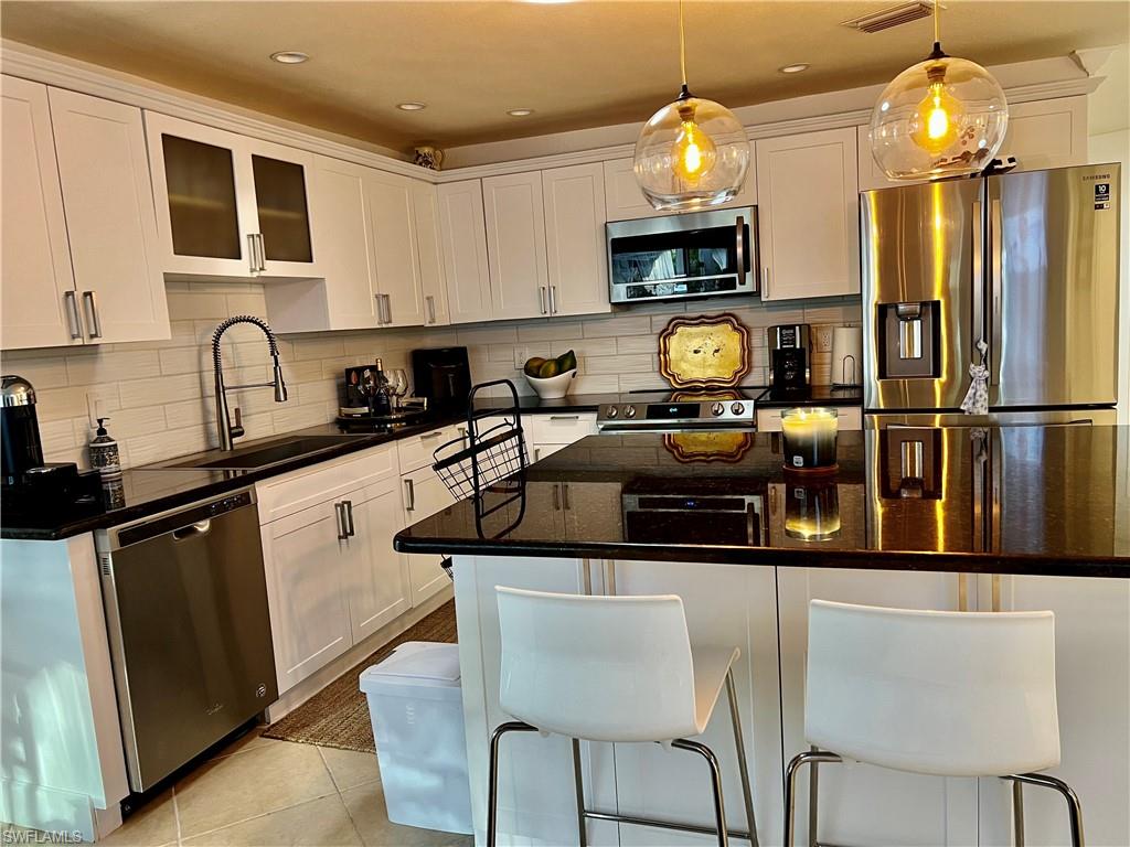 283 Cypress Way West Naples, FL 34110 - Photo 7 of 18 Living room featuring crown molding, light tile patterned floors, a ceiling fan, recessed lighting, and a chandelier