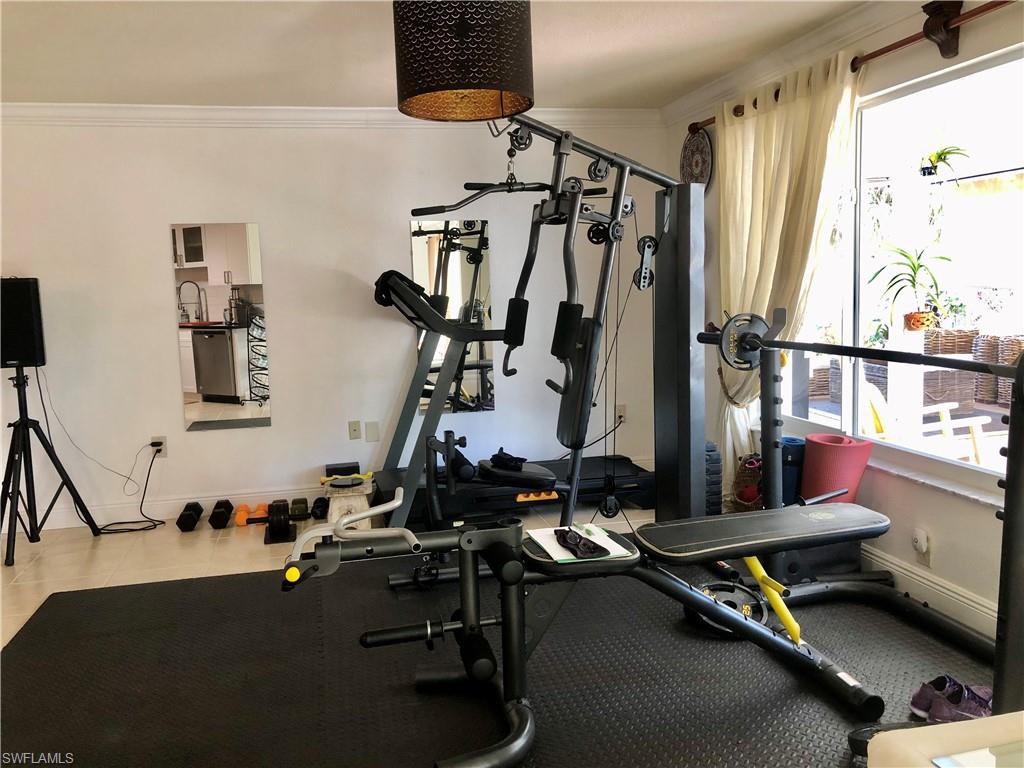 283 Cypress Way West Naples, FL 34110 - Photo 9 of 18 Dining area featuring a chandelier, light tile patterned floors, and crown molding